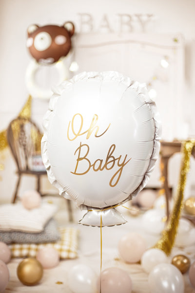 White balloon with 'Oh Baby' text in gold, surrounded by balloons and decor in a baby shower setting.