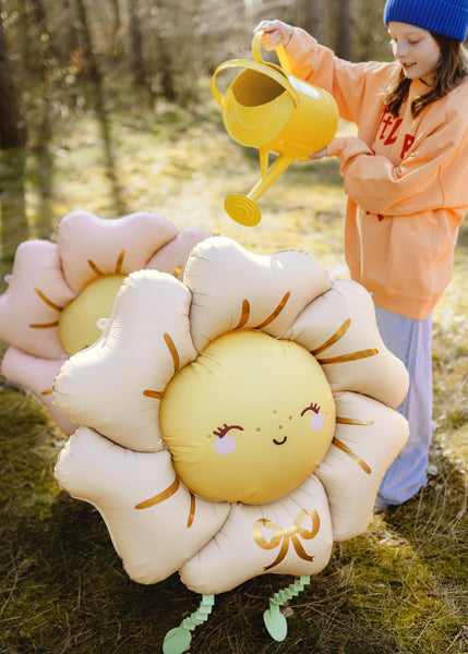 Little girl pretending to water flower balloons