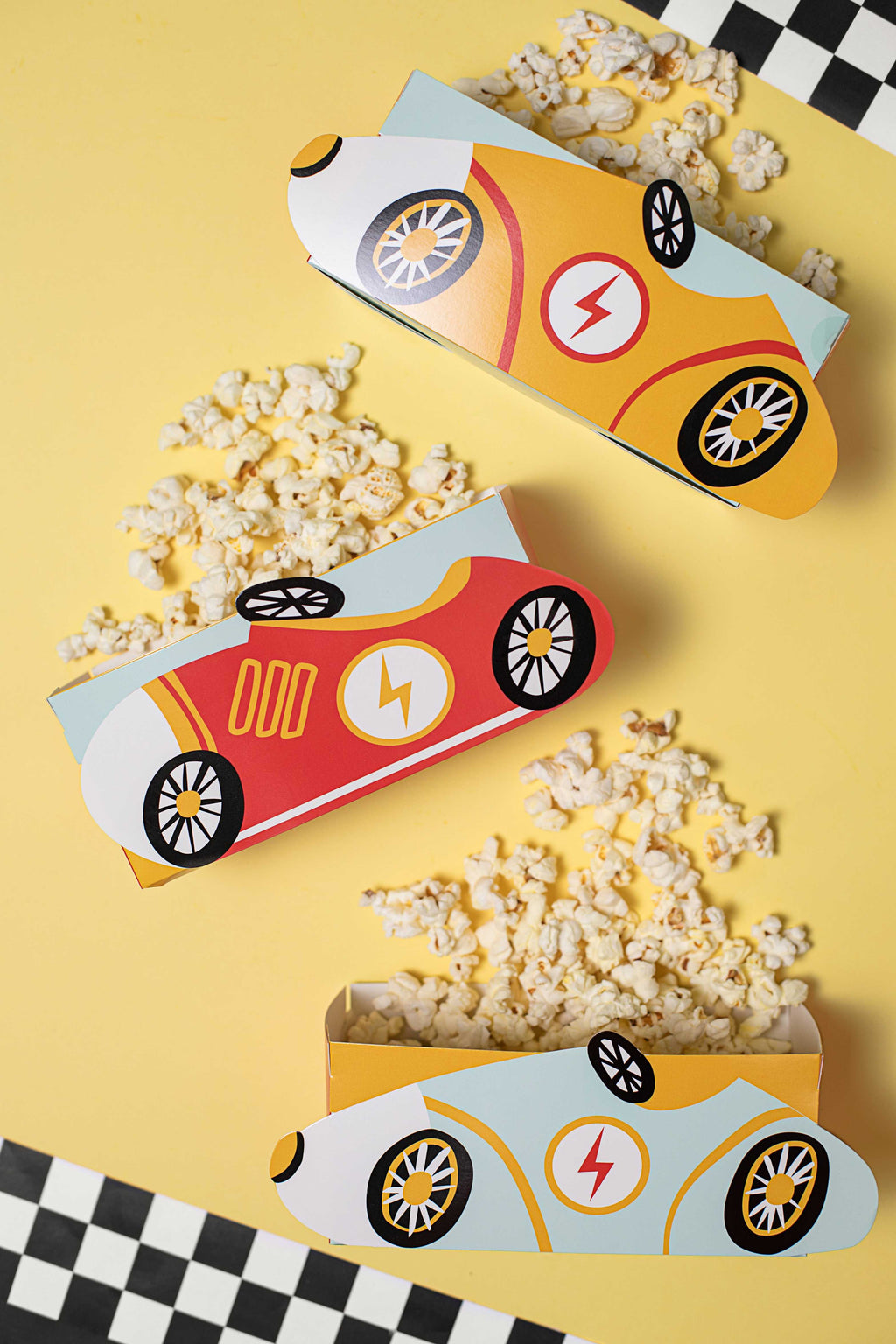 fun detailed shot of car racing snack boxes with popcorn coming out of them