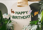 Dino Party Happy Birthday banner styled with dinosaur themed party decorations