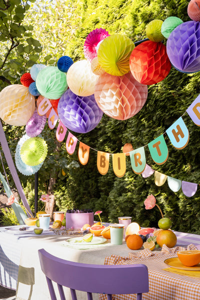 Colour Block Party scalloped birthday banner detail with gold foil letters with colourful decorations