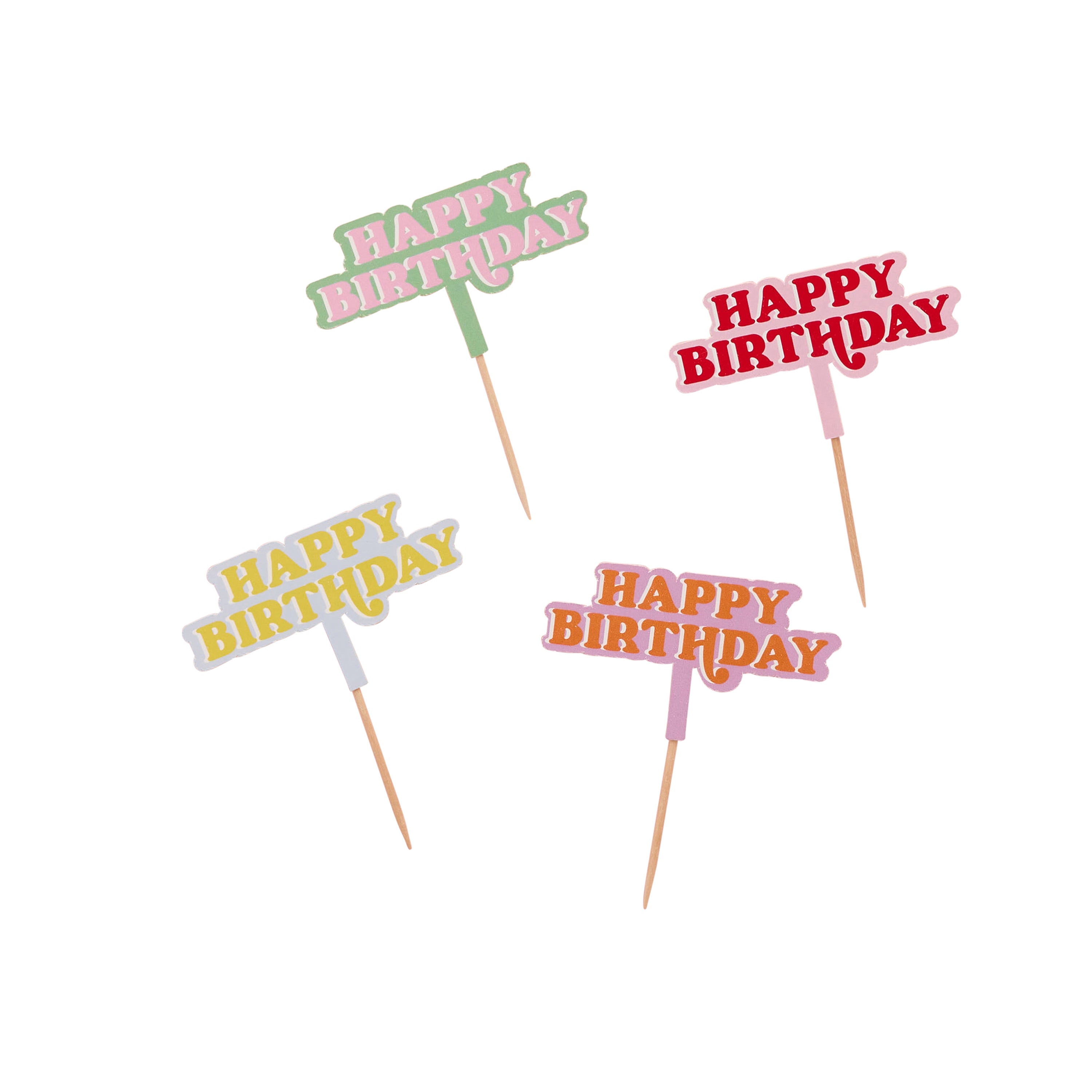 Four 'Happy Birthday' toppers in different colors on toothpicks against a white background.