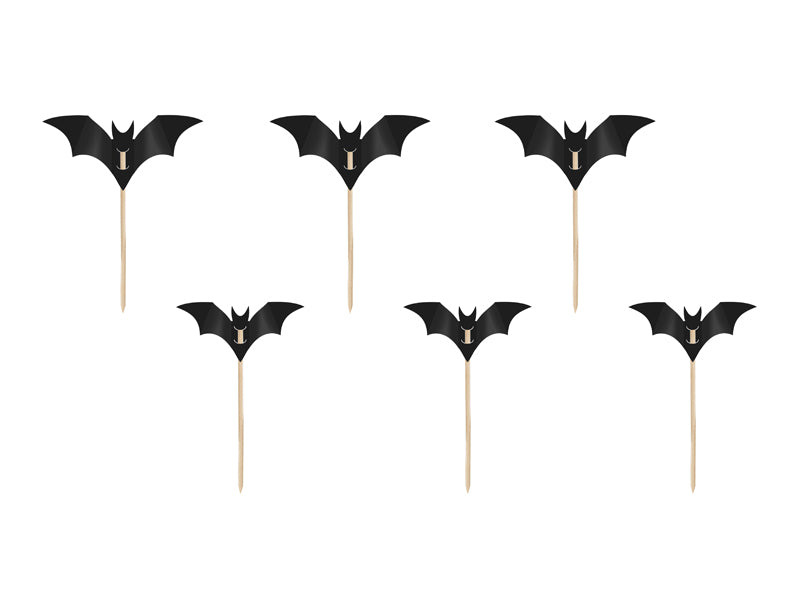 Black bat-shaped cupcake toppers on sticks against a white background
