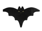 Black bat-shaped object with gold eyes 