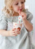 Child drinking from Pink pony paper cup and straw